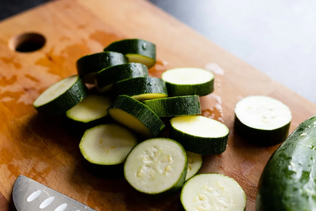 Zucchinischeiben auf einem Holzbrett, frisch geschnitten